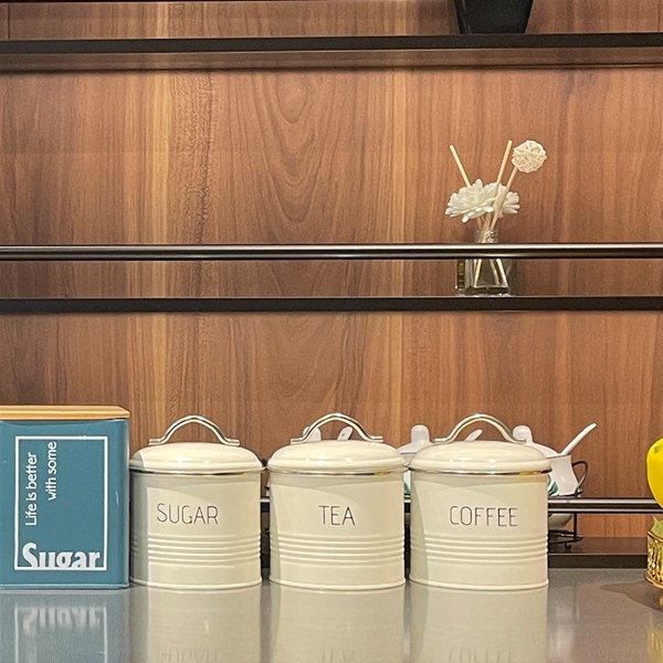 Три металлических чайника с сахаром, кофеварка, современная кухонная банка.